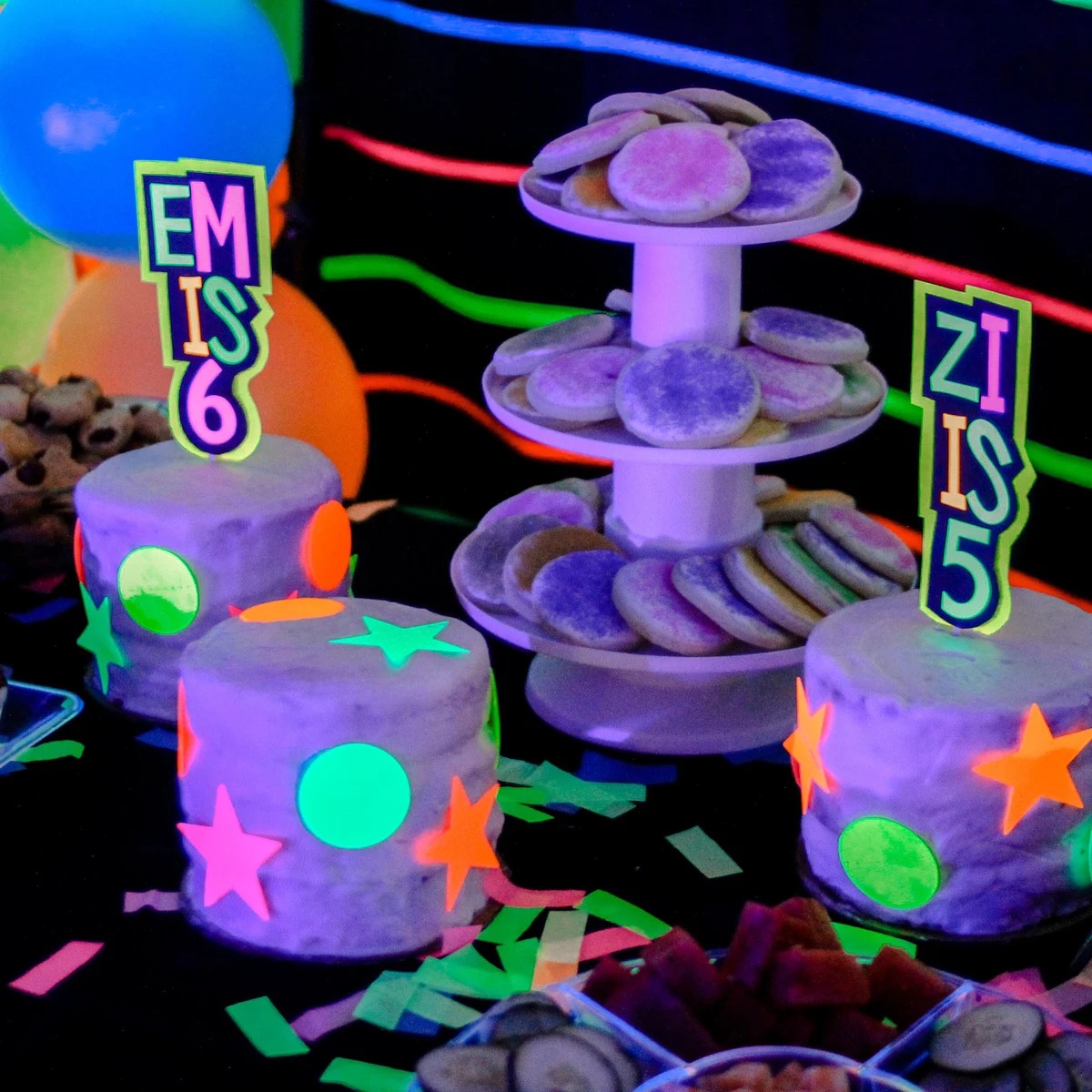 two custom neon cake toppers with names on two separate cakes